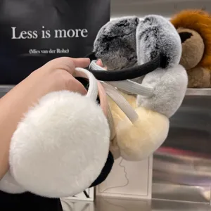 Close-up of fluffy ear warmers in white, gray, cream, and black, shown with soft padded cups