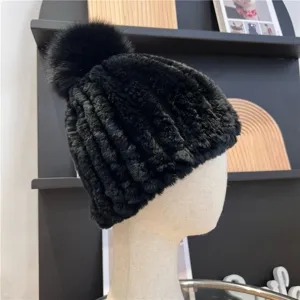 Close-up of a black ribbed knit hat with a fluffy pom-pom, shown on a mannequin head