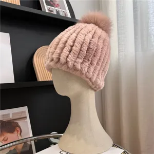 Side view of a pink rib-knit hat with a matching fluffy pom-pom displayed on a mannequin head