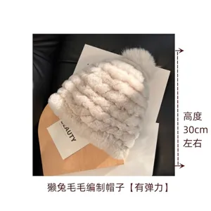 Close-up of a cream plush knitted hat with a pom-pom, shown with an approx. 30 cm height note