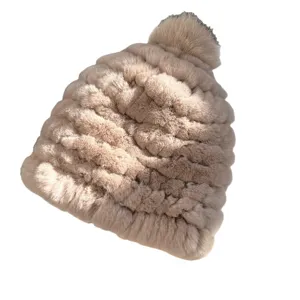 Beige plush knit winter hat with a textured design, matching pom-pom, and rolled brim
