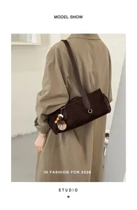 Back view shows a brown suede-textured shoulder bag with leather strap and wooden charm