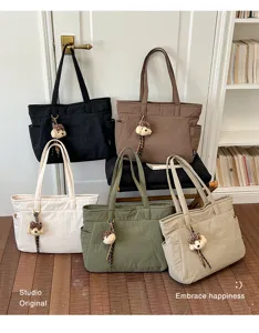 Cinq sacs cabas colorés avec des porte-clés hérisson en peluche, présentés en intérieur