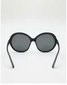 Rear view of black round sunglasses with dark gray lenses and slim temples on a white background