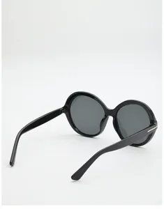 Angled rear-side view of black round sunglasses with dark gray lenses and metal temple accents
