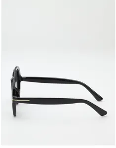 Side view of black round sunglasses with dark lenses and a slim gold metal accent on the temple