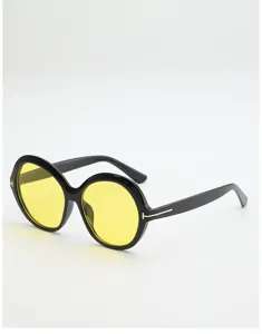 Angled view of yellow-tinted round lenses, black rims, and gold-tone T-shaped temple accents