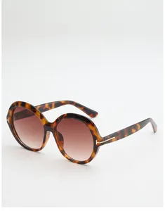 Angled view of tortoiseshell round sunglasses with brown gradient lenses and metal T-shaped accents