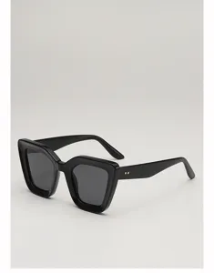 Vue de trois quarts de lunettes noires œil-de-chat, verres foncés et rivets dorés aux branches