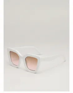 Vue oblique d'une monture blanche œil-de-chat, avec verres roses dégradés et petits rivets métalliques