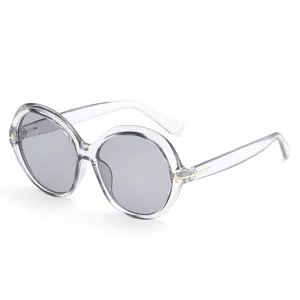 Oversized round sunglasses with clear gray plastic frames, gray lenses and T-shaped metal accents