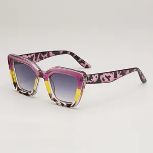 Lunettes cat-eye multicolores, branches roses léopard et verres gris dégradés, vue de biais