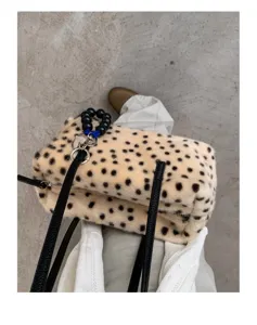 Draufsicht auf eine beige Kunstfelltasche mit schwarzen Punkten, Riemen und silbernem Haken.