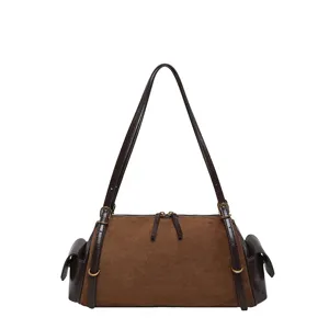 Front view of a brown suede bag with dark leather straps, side pockets and gold-tone hardware