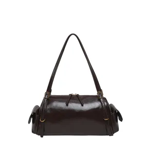 Front view of a glossy brown cylindrical bag with long strap, gold fittings and side flap pockets