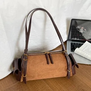 Brown suede shoulder handbag with dark leather straps, gold-tone hardware and side pockets
