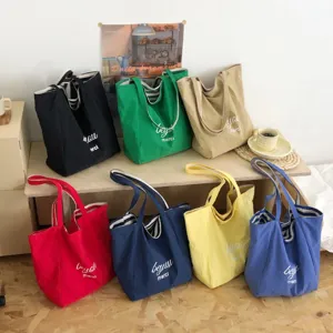 Siete bolsos tote de lona en varios colores, con forro a rayas y asas de mano y hombro
