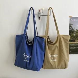 Bolsos tote de tela azul y caqui, con asas largas para el hombro y letras blancas “beyou merci”