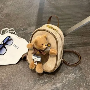 Beige suede-look mini backpack with brown leather trim, teddy bear charm and a plaid bow