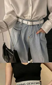 Nahaufnahme eines weißen Gürtels mit silberner Schnalle über hellblauer Jeans im Outfitbild