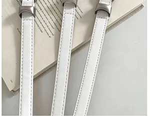 Κοντινή λήψη τριών λευκών λουριών από τεχνητό δέρμα, με γκρι ραφές και ασημί μεταλλικά κουμπώματα