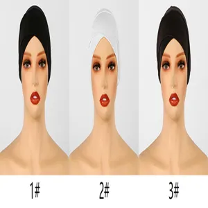 Trois têtes de mannequin présentent des couvre-chefs croisés en maille, noirs, blancs et brun foncé.