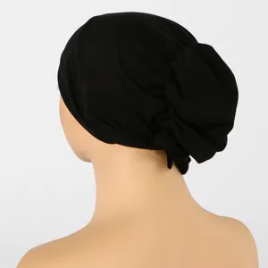 Vue arrière latérale d’un bonnet noir en maille, avec des plis froncés et un détail noué visible