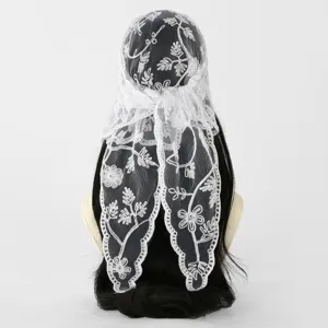 White floral lace with embroidered motifs draped over a black-haired mannequin, shown from behind