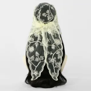 Pale yellow lace scarf with floral embroidery and openwork edging draped over a mannequin wig