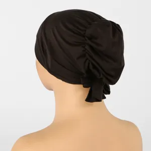 Vue arrière d’un bonnet extensible brun foncé, avec plis froncés et lien noué à l’arrière
