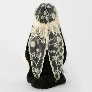 Ivory floral lace headscarf tied over dark hair, showing embroidered vines and scalloped edges