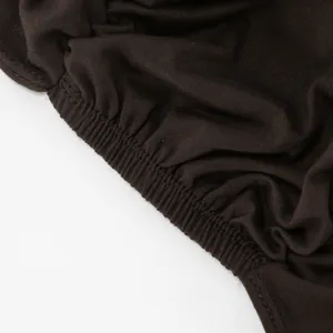 Gros plan sur un tissu tricoté extensible brun foncé, à texture lisse et bordure élastique froncée