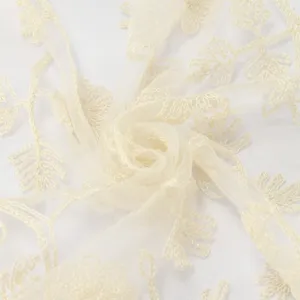 Close-up of sheer ivory mesh with glossy embroidered leaf motifs, softly gathered to show its drape