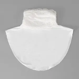 Flat lay of a white lace-trimmed collar with a smooth fabric panel against a gray background