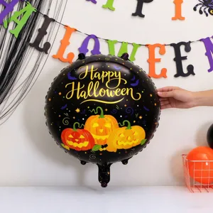 Close-up of a black foil balloon with gold Happy Halloween lettering and pumpkin designs