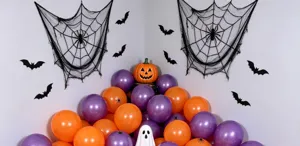 Halloween display with purple and orange balloons, black spiderwebs and bats, plus a pumpkin