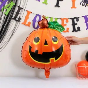 Shiny orange foil pumpkin balloon with a smiling face, green leaves and brown stem on display