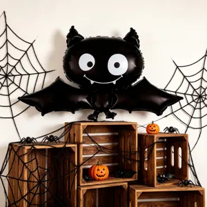Halloween display with a smiling black bat balloon, wide wings, spiderwebs, wooden crates and pumpkins