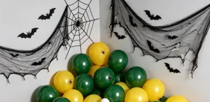 Halloween display with green and yellow balloons, black spider accents, web netting and bat cutouts
