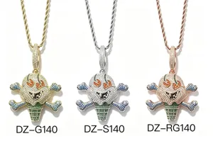 Drei mit Steinen besetzte Totenkopf-Eiscreme-Anhänger in Gold, Silber und Roségold auf weißem Grund