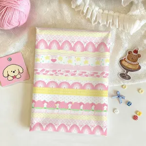 Flat lay detail of pink printed fabric with strawberries, stripes and small decorative motifs
