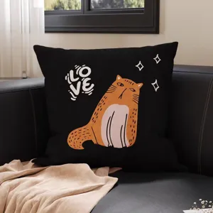 Schwarzes Kissen mit orangefarbener Katze und weißem „LOVE“-Schriftzug auf dunklem Sofa