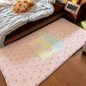 Pink plush bedside runner rug with pastel cartoon house and star patterns, shown beside a bed