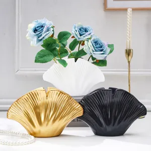 Trois vases en forme d'éventail, doré, blanc et noir, avec des roses bleues dans le vase blanc