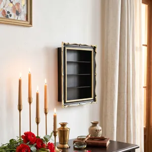 Black tiered shelves with ornate gold trim displayed on a wall in a softly lit, elegant interior
