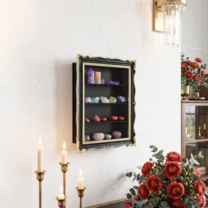 Wall scene with a black cabinet, ornate gold trim, crystal specimens, and warm home decor