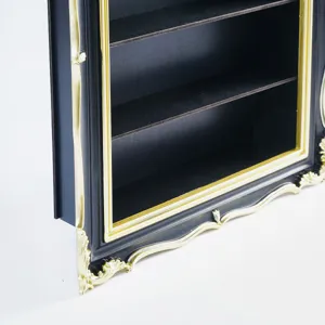 Close-up of dark display shelves with ornate gold trim and carved detailing on a black frame