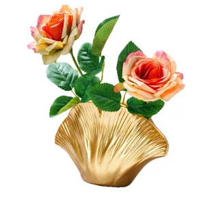 Vase doré en éventail de ginkgo, avec deux roses artificielles orange rosé et feuillage vert
