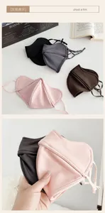 Folded masks in black, gray, brown and pink, with a hand-held close-up of soft fabric and ear loops