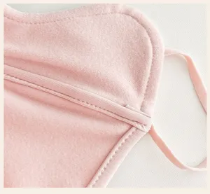 Close-up of soft pink thermal mask fabric, stitched edging and slim adjustable tie straps